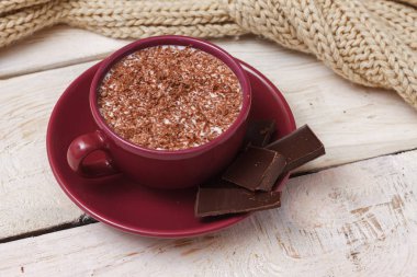 Sütlü çikolata bir fincan hafif ahşap arka plan üzerinde bir daire üzerinde