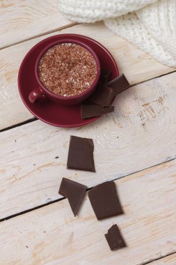 Sütlü çikolata bir fincan hafif ahşap arka plan üzerinde bir daire üzerinde