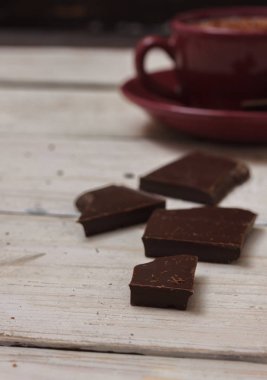 Sütlü çikolata bir fincan hafif ahşap arka plan üzerinde bir daire üzerinde