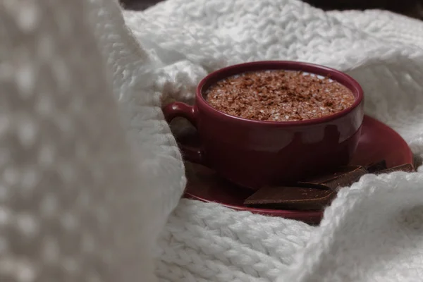 Молочный шоколад в чашке на блюдце на фоне мешка — стоковое фото