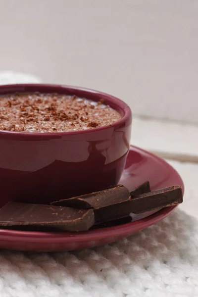 Chocolate de leite em uma xícara em um pires contra um contexto de um sc — Fotografia de Stock