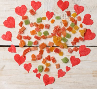 Beyaz ahşap backg üzerinde küçük kırmızı kağıt kalplerin yapılan büyük kalp