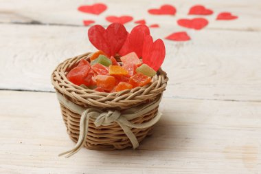 Parlak şekerleme tabağı. Beyaz ahşap arka yüzündeki bir kağıttan kırmızı kalp