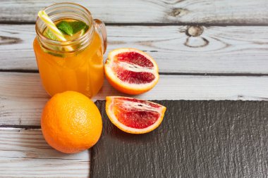 Fresh orange on a wooden background. Juice in a jar. Summer drink. Orange on a wooden background.