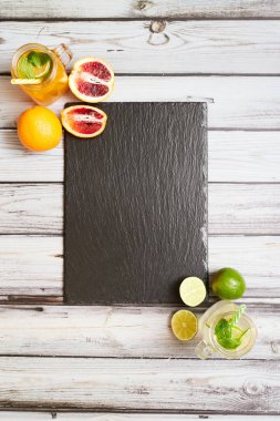 Summer drinks. Fresh freshes on a slate board. View from above. Orange, lemon and strawberry fresh.