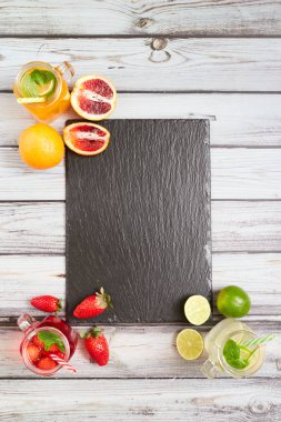 Summer drinks. Fresh freshes on a slate board. View from above. Orange, lemon and strawberry fresh.