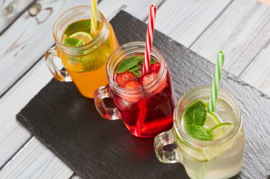 Yaz içkileri. Karanlık tahtada taze taze tazelikler. Portakal, limon ve çilek taze.