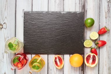 Summer drinks. Fresh freshes on a slate board. View from above. Orange, lemon and strawberry fresh.