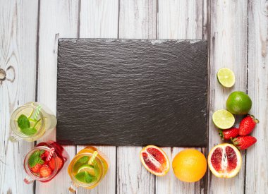 Summer drinks. Fresh freshes on a slate board. View from above. Orange, lemon and strawberry fresh.