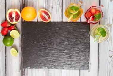 Summer drinks. Fresh freshes on a slate board. View from above. Orange, lemon and strawberry fresh.