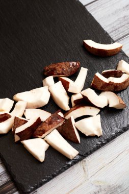 Whole coconut with pieces on a dark background.