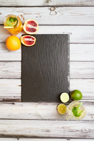 Summer drinks. Fresh freshes on a slate board. View from above. Orange, lemon and strawberry fresh.