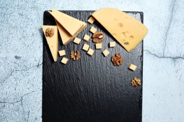 Koyu arkaplanda ceviz olan peynir parçaları..