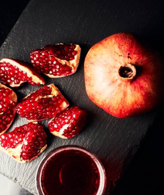 Koyu arkaplanda nar suyu. Yaz içeceği. Koyu arkaplanda nar. Yukarıdan görüntüle.