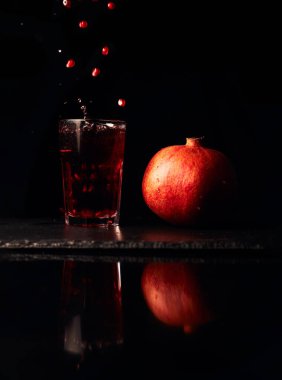 Koyu arkaplanda nar suyu. Yaz içeceği.