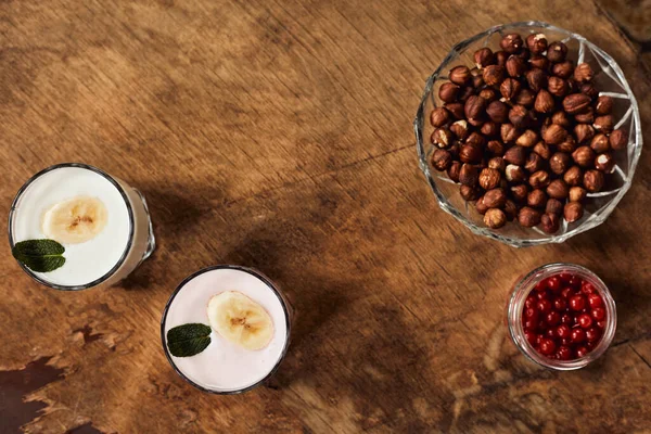 Joghurt Mit Nüssen Auf Einem Hölzernen Hintergrund Blick Von Oben lizenzfreie Stockbilder