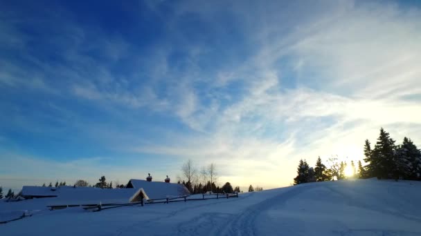 阴云密布 夕阳笼罩在寒冷的冬日里的小村子里 村下雪地上的小径 — 图库视频影像