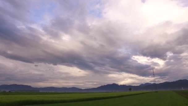 Solnedgång Med Moln Över Små Kullar Och Större Berg Långt — Stockvideo