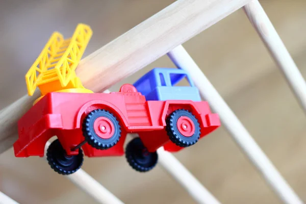 Kleine Brandweerman Plastic Baby Speelgoed Auto Een Houten Kinderbedje Spelen — Stockfoto