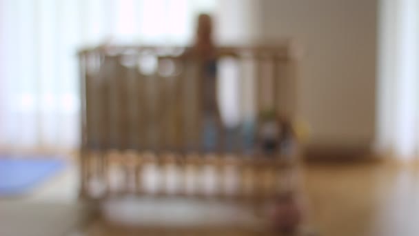 Fuera Foco Una Cuna Madera Con Bebé Jugando Ella Solitario — Vídeo de stock