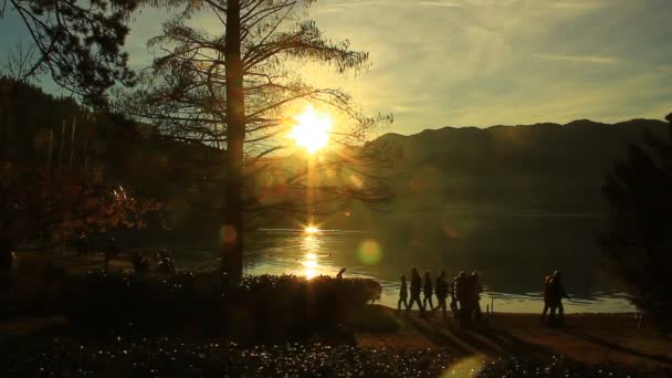 Silhouete Persone Sconosciute Passeggiando Lungo Lago Alla Fine Della Giornata — Video Stock