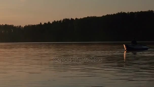 Ensam man ridande på en roddbåt på sjön skymning tid. Gyllene solnedgång soluppgång på sjön. Leisure natur koncept — Stockvideo