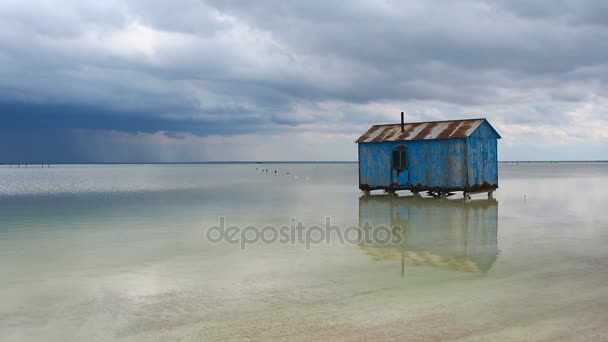 Antigua casa azul abandonada en medio del lago salado durante una tormenta que se aproxima. Salar Baskunchak — Vídeo de stock