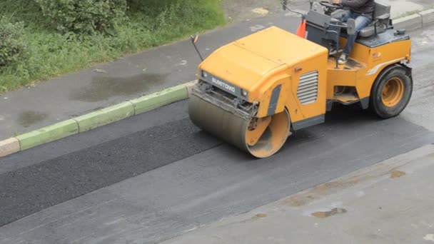 Domodedovo, Rusya - 17 Mayıs 2017: yol onarım yapıyor ve sokaklarında, yolun yol onarım ile bina yeni bölüm parke yol silindiri — Stok video