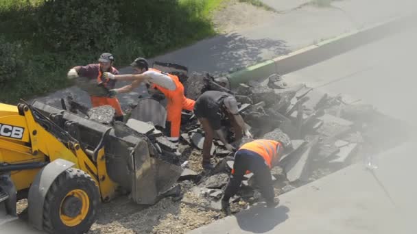 Domodědovo, Rusko - 17. května 2017: Silniční pracovníků načíst kusy starého asfaltu do kbelíku buldozer... Opravu povrchu vozovky. Pracovníky odstraněny vrstvy asfaltu. — Stock video