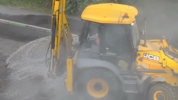 DOMODEDOVO, RUSSIA - 17 MAGGIO 2017: Gli operai della strada caricano pezzi di asfalto vecchio in un secchio bulldozer.. Sezione di riparazione del manto stradale. Lavoratori rimosso strato di asfalto . — Video Stock