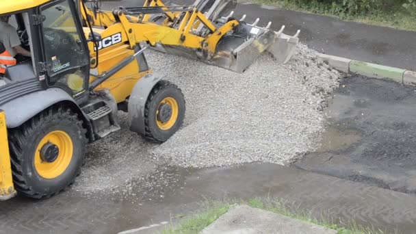 Domodedovo, Rusya Federasyonu - 17 Mayıs 2017: Bir buldozer moloz yığını taşlama. Erkekler işte. Onarım ve yollarının yapımı. Kaldırım asfalt kaplama — Stok video