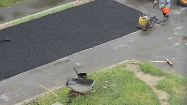 Domodedovo, Ryssland - 17 maj 2017: Komprimering av asfalt med en roller. Tätning asfalt med en vibroplatta. Asfaltbeläggning förnya — Stockvideo