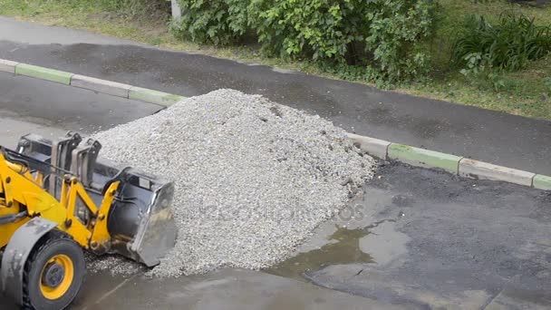 Domodedovo, Rusya Federasyonu - 17 Mayıs 2017: Yol işçileri eski asfalt parçaları bir buldozer kova içine yük... Yol yüzeyi bölümünde onarmak. İşçiler asfalt tabakası kaldırıldı. — Stok video