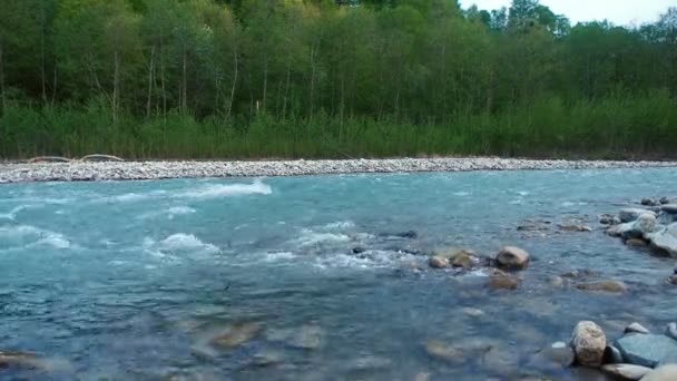 Чистая горная река с сильным течением стремительно стекает с гор Кавказа — стоковое видео