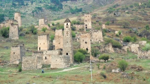 Sight Towers and Defensive Towers of the North Caucasus (en inglés). Edificios históricos monumentales medievales en las montañas. Personas caminando cerca de lugares de interés histórico en Ingushetia . — Vídeo de stock