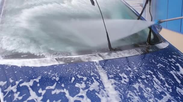 Lavado de autos. Un chorro de agua con una fuerte presión lava la espuma del vidrio del coche — Vídeos de Stock