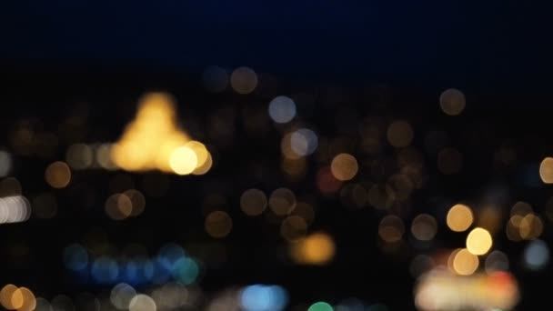 Noche desenfocada Vista de la ciudad europea desde arriba. El movimiento de los coches en la carretera en la noche. Luz nocturna del casco antiguo — Vídeo de stock