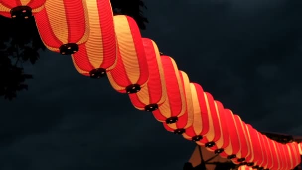 Röd-vit japanska papperslyktor Chochin lyser på mörk himmel — Stockvideo