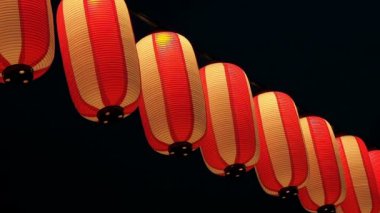 Kağıt kırmızı-beyaz Japon lambaları Chochin karanlık gökyüzünde parlayan.