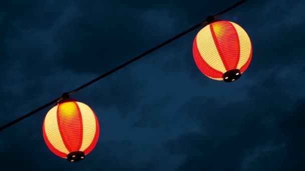 Kağıt kırmızı-beyaz Japon lambaları Chochin karanlık gökyüzünde parlayan. — Stok video