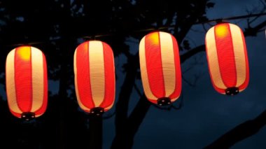 Kağıt kırmızı-beyaz Japon lambaları Chochin karanlık gökyüzünde parlayan.