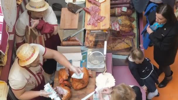 Moskou, Rusland - 20 September 2017: Slager leverancier man verkopen gerookt vlees Turkije worst en ham voor vrouw op vlees eerlijke. Slagerij van Europa — Stockvideo