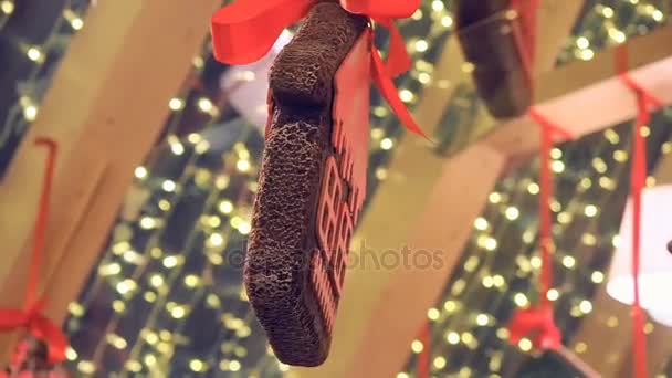 Galletas de recuerdo decoradas con adornos de invierno, el comercio minorista hunging en la feria de Navidad en la calle. Año Nuevo Decoraciones callejeras pan de jengibre y guirnaldas brillantes — Vídeo de stock