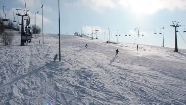 Narciarzy i snouborders na działanie wyciągu narciarskiego w okresie zimowym. Kolejki linowej wyciągów Narodów do stoku — Wideo stockowe
