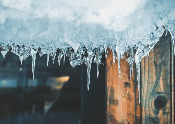 buz buz sarkıtları evin çatısından asılı.