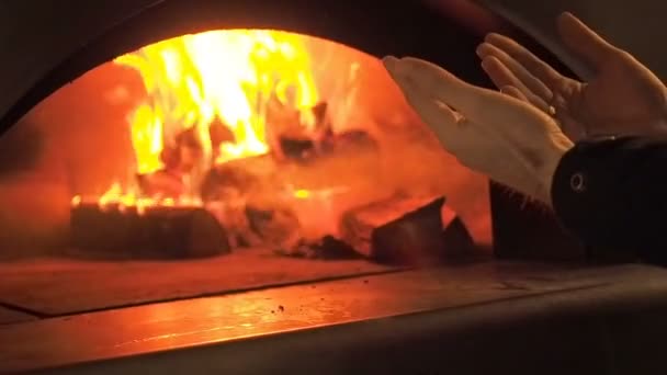 O homem aquece as mãos junto ao fogo. Fogo de fornalha. Vídeo clipe de lenha queimando na lareira. A lenha arde no forno. 30fps Full HD . — Vídeo de Stock