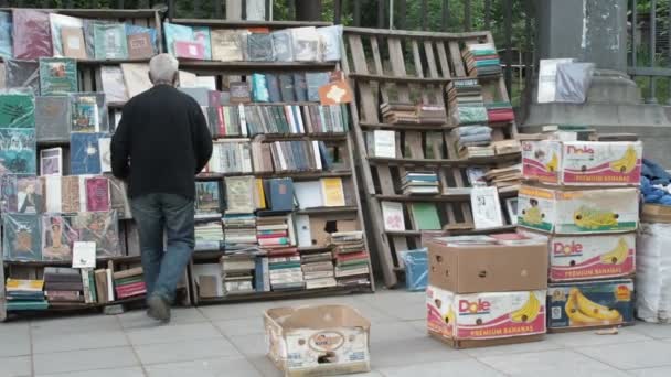 GEORGIA - TBILISI, 27 DE MAYO DE 2017 - El anciano vende libros en la calle, vendedor de pequeñas empresas, Tiflis, Georgia — Vídeo de stock
