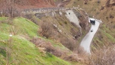 Dağ manzarası. Dağlarda geçen yol. Arabalar dağlarda yolda ilerliyorsunuz. Yol serpantin Kafkasya dağlarında. Otomobil trafik ulaşım Üstten Görünüm