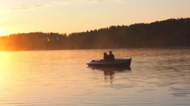 Romantik altın günbatımı nehir Gölü sis sevgi dolu çift küçük kürek teknesi tarihi güzel aşık sırasında mutlu kadın erkek birlikte su doğa çevresinde rahatlatıcı binmek. 50 fps