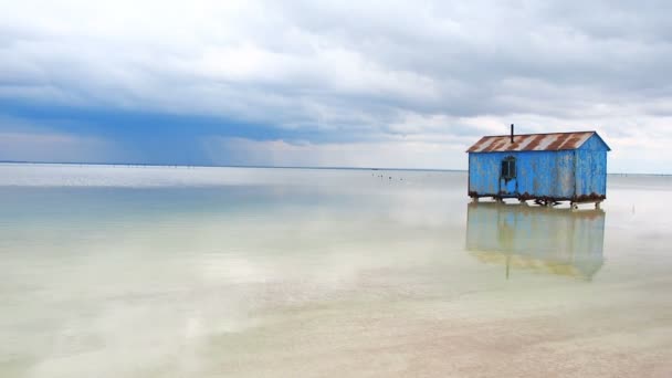 Yaklaşan bir fırtına sırasında Tuz Gölü ortasında terk edilmiş eski mavi ev. Salar tuzlu tuzlu tuzlu göl Dead Sea Baskunchak — Stok video